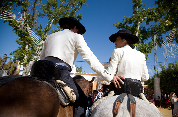Festliche Reiter auf ihren Pferden von hinten betrachtet.