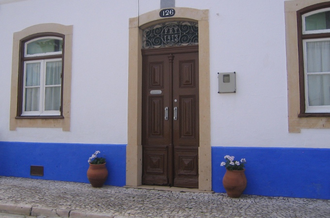 Typische Hausfassade mit hölzernem Eingangsportal in Portugal