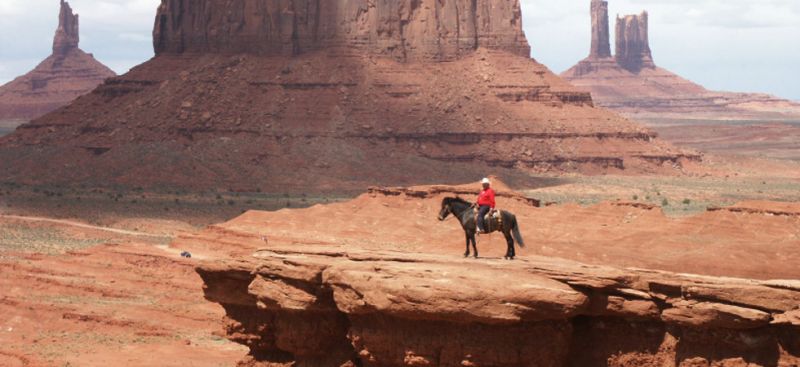 Cowboy zu Pferd an einem Canyon - Reiterreisen USA.
